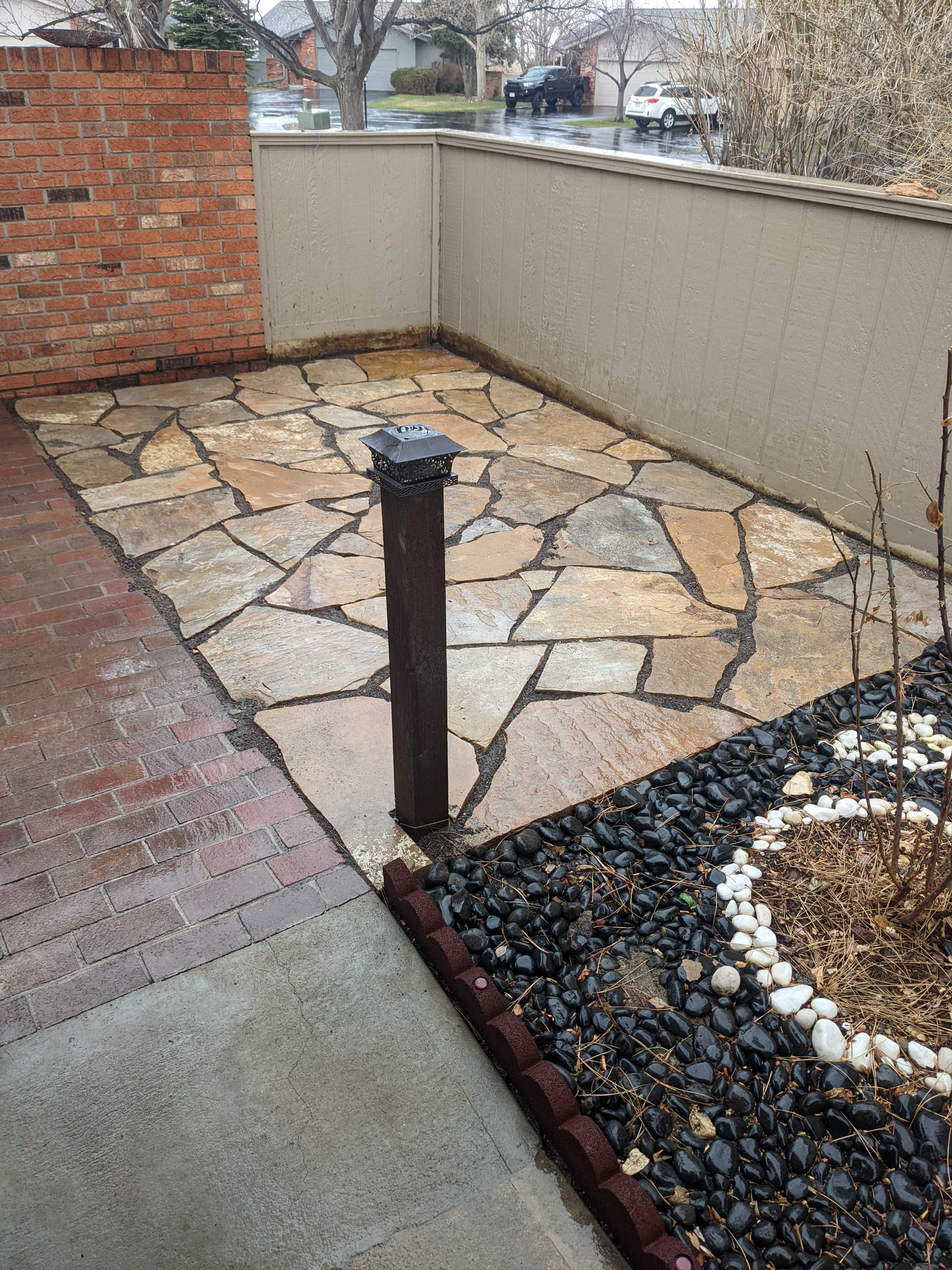 Stone patio next to rock beds in a backyard with hardscape design in Fort Collins