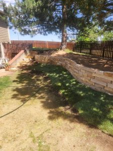 A large retaining wall in a freshly landscaped yard in Fort Collins by Linden Leaf Landscapes