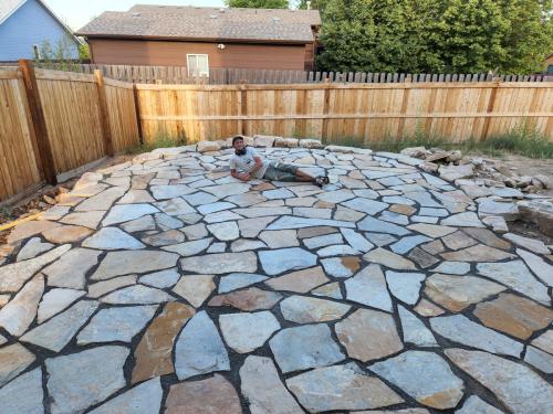 Linden Hunter of Linden Leaf Landscapes laying on one of his flagstone patios in Fort Collins