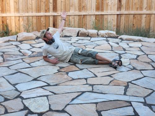 Linden Hunter of Linden Leaf Landscapes laying on one of his flagstone patios