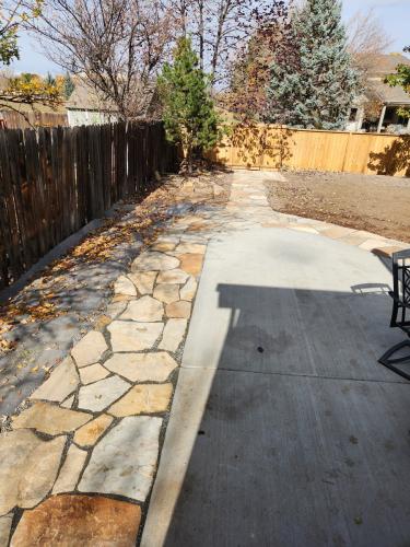 Hardscape flagstone patio and outdoor living space with concrete