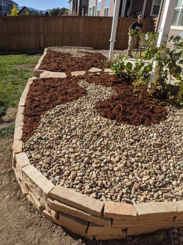 Rock planter bed wit pebbles and mulch landscape design in Fort Collins