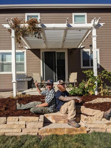 Linden Hunter of Linden Leaf Landscapes posting in front of a xeriscape design in Fort Collins