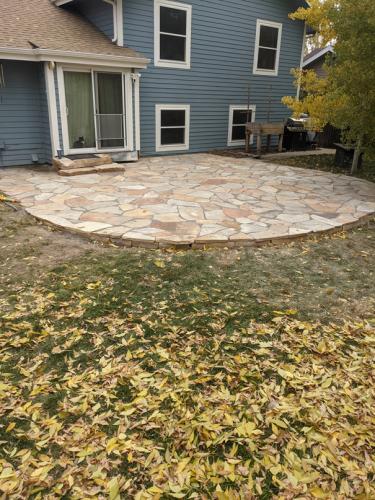 Large curved stone patio by Linden Leaf Landscapes in Fort Collins