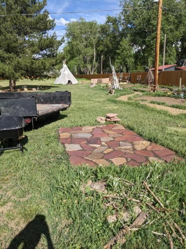 Large grass yard with stone patio section in Fort Collins