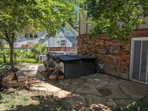 Green backyard with trees and custom stone patio