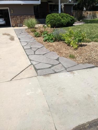 Flagstone xeriscape work alongside cement pathway in Fort Collins